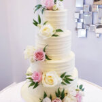 four tier wedding cake with pink and white roses