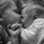 Newborn baby with toddler sibling cute kiss