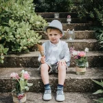 young boy sat on the steps at a wedding