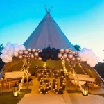 Event tipi decorated with lights and balloons